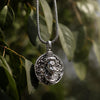 Handcrafted silver Shiva pendant necklace with intricate detailing, hanging on a leafy branch