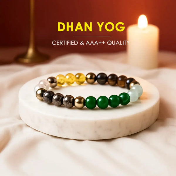 Colorful gemstone bead bracelet on white marble slab with candle in background