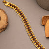 Gold chain rudraksha bracelet with brown beads on a neutral background