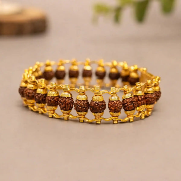 Rudraksha bead bracelet with gold-tone metal links on neutral background