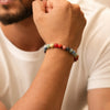 Man wearing a colorful beaded gemstone bracelet on wrist, close-up view