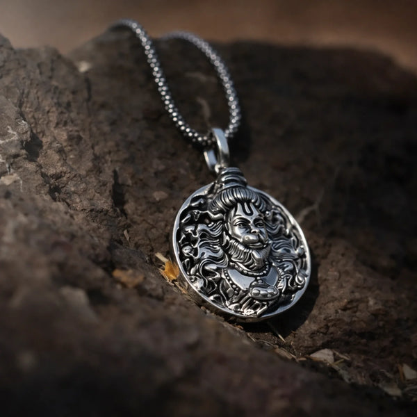 Silver round pendant necklace with intricate deity relief on natural stone background