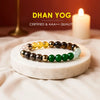 Colorful gemstone bead bracelet on white marble slab with candle in background