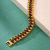 Rudraksha and gold-toned chain bracelet displayed on a green and white surface