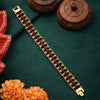 Gold plated Rudraksha bracelet with intricate links on a green fabric, floral and wooden decor