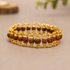 Rudraksha bead bracelet with gold-tone metal links on neutral background