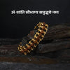 Rudraksha beaded bracelet with gold accents on a dark stone background