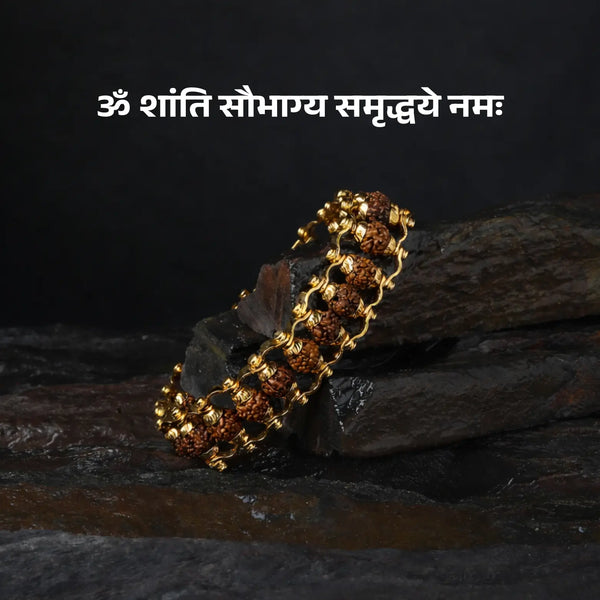 Rudraksha beaded bracelet with gold accents on a dark stone background